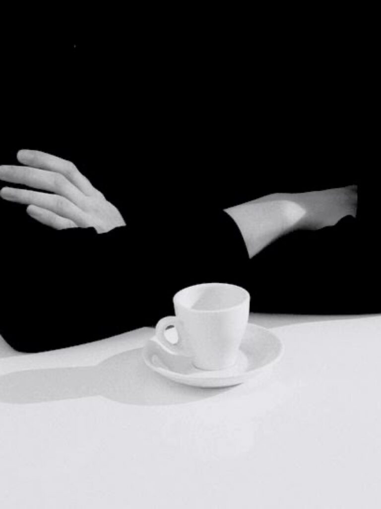 Minimalistička scena ruku preduzetnika pored šolje kafe, simbol emocionalne regulacije i smirenosti