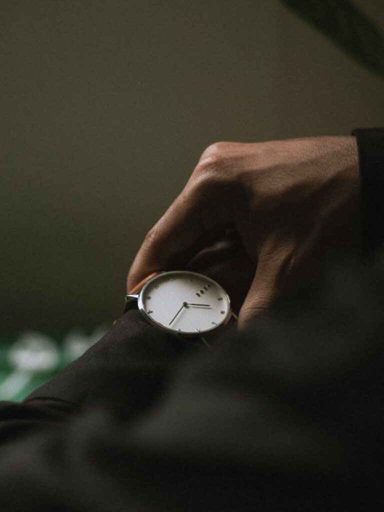 Ruka preduzetnika koji proverava vreme na minimalističkom satu, simbol fokusa i poslovnih odluka